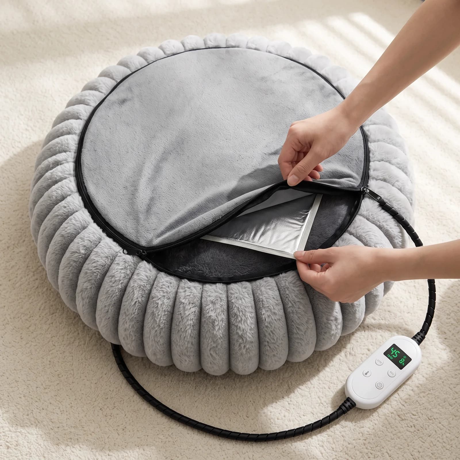 The zip on the base of the bed opened to show the heating pad pocket under the plush cushion